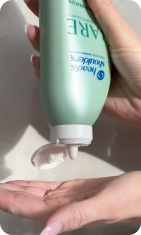Woman pouring a bottle of shampoo